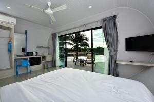 una camera con un grande letto bianco e una porta scorrevole in vetro di Krabi Boat Lagoon Resort a Krabi town
