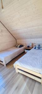 2 łóżka w pokoju z drewnianym sufitem w obiekcie Domki Halo Morze w Jastrzębiej Górze