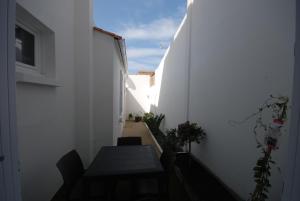 einen kleinen Flur mit einem Tisch und einer weißen Wand in der Unterkunft La réserve à bonheurs in Les Sables-dʼOlonne