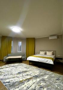 um quarto de hotel com duas camas e um sofá em MINI HOTEL COMFORT em Shymkent