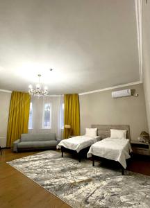 sala de estar con 2 camas y sofá en MINI HOTEL COMFORT, en Shymkent