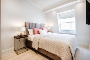 倫敦的住宿－Marble Arch Suite 4-Hosted by Sweetstay，一间卧室配有带粉红色枕头的床和窗户。