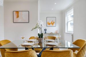 倫敦的住宿－Marble Arch Suite 4-Hosted by Sweetstay，一间设有玻璃桌和椅子的用餐室