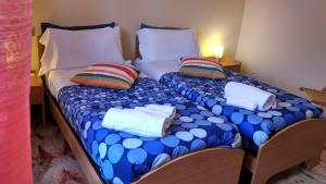 two twin beds with pillows and towels on them at B&B L'Aquila in LʼAquila