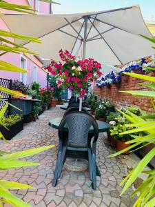 patio con tavolo fiorito e ombrellone di Hotel Paris a Mestre