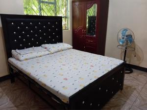ein Schlafzimmer mit einem Bett mit Polka-Punkten darauf in der Unterkunft Airb&b Homestay in Boma la Ngombe