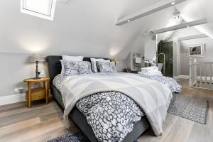 - une chambre avec un lit et une couette noire et blanche dans l'établissement Woodbridge House Apartment, à Londres