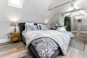 a bedroom with a bed with a black and white comforter at Woodbridge House Apartment in London
