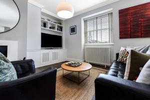 - un salon avec un canapé et une table dans l'établissement Woodbridge House Apartment, à Londres
