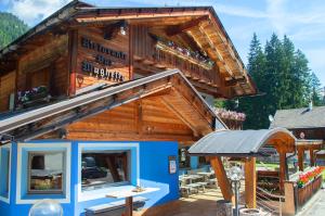 a log cabin with a roof and a patio at Al Mughetto in Auronzo di Cadore