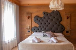 a bedroom with a large bed with a large headboard at Al Mughetto in Auronzo di Cadore