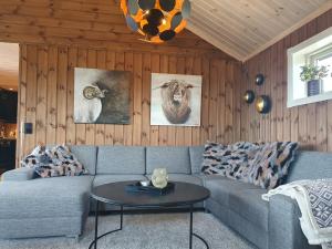 a living room with a couch and a table at Wonderful cabin with amazing mountain - view in Lifjell