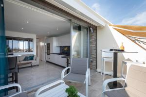 een open woonkamer en keuken met witte meubels bij Village Naturiste - Xcape Sea View Luxe in Cap d'Agde