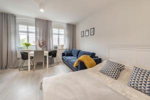 salon z łóżkiem i niebieską kanapą w obiekcie Apartamenty Śnieżna 12 Lądek- Zdrój w mieście Lądek-Zdrój