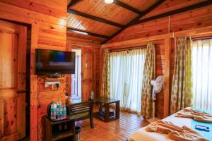 バガにあるCasa De Silverの木製の壁のベッドルーム、薄型テレビが備わります。