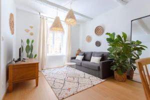 een woonkamer met een bank en een tapijt bij Grand T2 - 100 m de la mer - CLIM in La Ciotat