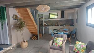 ein Wohnzimmer mit einer Treppe und eine Küche in der Unterkunft RÊV BOR D'MER in L'Étang-Salé-les-Bains