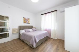ein Schlafzimmer mit einem Bett und einem großen Fenster in der Unterkunft Apartment Iva in Dubrovnik