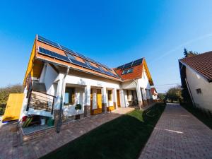 a house with solar panels on the side of it at Kun Pista Vendégház III in Vértesboglár