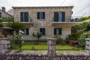 ein Steinhaus mit einem Zaun davor in der Unterkunft Apartment Iva in Dubrovnik