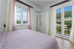 ein Schlafzimmer mit großem Bett und großen Fenstern in der Unterkunft Apartment Iva in Dubrovnik