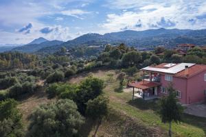 eine Luftansicht eines rosa Hauses auf einem Hügel in der Unterkunft La Collina degli Ulivi in Bari Sardo