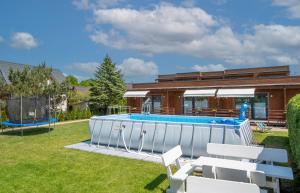 a swimming pool in a yard with a house at Baltic Resort in Mielno