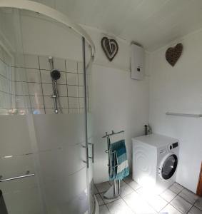 a bathroom with a shower and a washing machine at Koch's Apartment in Solingen