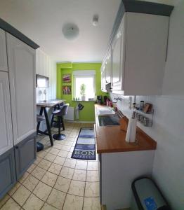 una cocina con armarios verdes y blancos y una mesa en Koch's Apartment, en Solingen