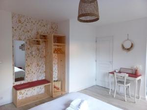 a bedroom with a bed and a desk and a mirror at Le Clos Beauséjour in Montjean-sur-Loire
