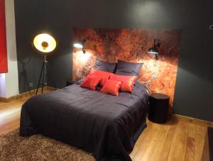 a bedroom with a large bed with red pillows at Au Moulin des Fées - Maison d'hôtes Cascades du Hérisson in Bonlieu