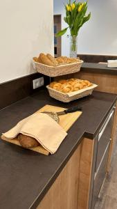 zwei Körbe Brot und Brotlaibe auf einer Theke in der Unterkunft Das Joes Frühstückspension 