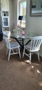 comedor con mesa de cristal y 2 sillas blancas en Koch's Apartment, en Solingen