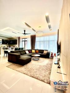 uma sala de estar com um sofá e uma mesa em Batu Ferringhi Luxurious Modern Designed 5BR House em Batu Ferringhi