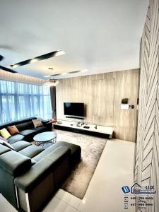 uma sala de estar com um sofá e uma televisão em Batu Ferringhi Luxurious Modern Designed 5BR House em Batu Ferringhi