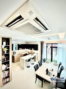 Batu Ferringhi Luxurious Modern Designed 5BR House في باتو فيرينغي: غرفة معيشة مع طاولة وكراسي ومطبخ