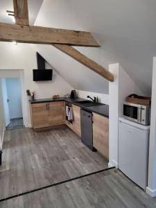 a kitchen with wooden floors and a counter top at Appartement proche circuit in Changé