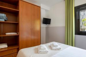 a bedroom with a bed with two towels on it at Apartments Sata Park Guell Area in Barcelona