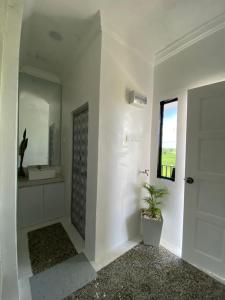 a white bathroom with a sink and a mirror at LamanLeman Langkawi in Pantai Cenang