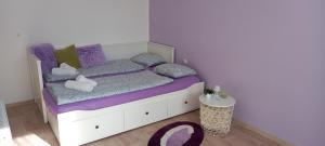 Schlafzimmer mit einem Bett mit lila Bettwäsche und Kissen in der Unterkunft Garsonka ve Dvoře in Dvůr Králové nad Labem