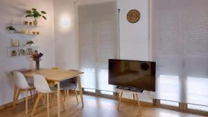 a dining room with a table and a television at Precioso apartamento duplex en el centro de Olot in Olot