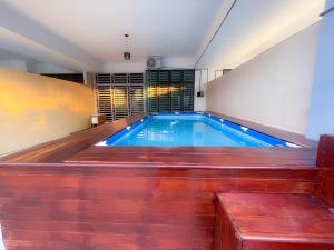 a swimming pool in a house with a wooden floor at Sulong Inn - Private Pool Homestay in Kuantan, Pantai Sepat in Kuantan