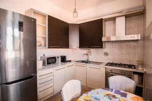 eine Küche mit einem Tisch und einem Kühlschrank aus Edelstahl in der Unterkunft Yourquadrarooms B&b in Rom