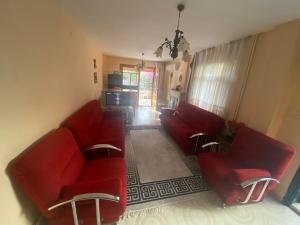 una sala de estar con 2 sofás rojos en özdere tripleks yazlık 4 oda, en Özdere