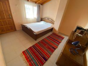 Dormitorio pequeño con cama y alfombra en özdere tripleks yazlık 4 oda, en Özdere