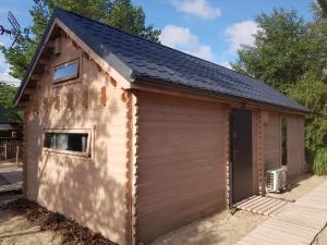 a shed with a black roof at Sea You Soon w Sztutowie in Sztutowo