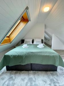 a bedroom with a green bed in a attic at FeWo-Julius am Weser-Sandstrand in Berne