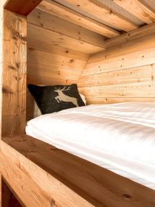 a bed in a wooden cabin with a pillow at Chalet Zugspitze in Kurort Altenberg