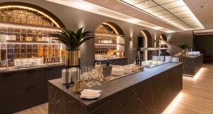a restaurant with a long counter with plates and glasses at PLAZA Premium Columbus Bremen in Bremen