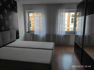 sala de estar con sofá blanco y 2 ventanas en 3 Zimmer Wohnung Zentrumsnähe, en Aachen